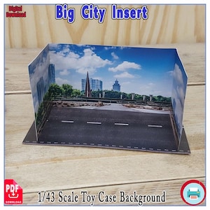 Puede incluir: Fondo de vitrina de juguete a escala 1/43 con una escena urbana. El fondo presenta una carretera con marcas blancas, un puente y edificios altos bajo un cielo azul con nubes. El texto "Big City Insert" está en la parte superior.