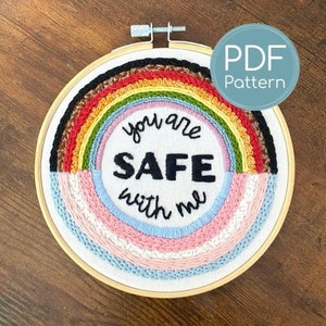 May include: Embroidered hoop art with a rainbow design and the text "You are safe with me".