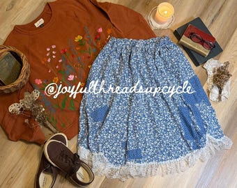 Jupe fleurie bleue recyclée avec ourlet mouchoir, bordure en dentelle et poches plaquées