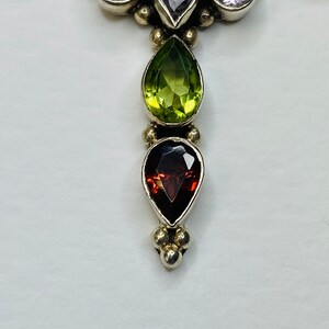 Peut inclure: Un pendentif en argent avec un groupe de pierres pr&eacute;cieuses violettes et une rang&eacute;e de pierres pr&eacute;cieuses vertes, rouges et violettes.