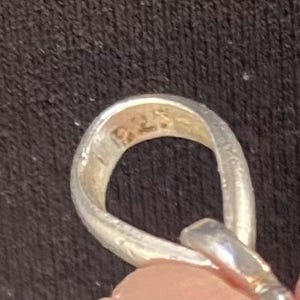 Peut inclure: Gros plan d'un pendentif en argent avec une boucle en haut. Le pendentif porte l'inscription "92.5" &agrave; l'int&eacute;rieur.