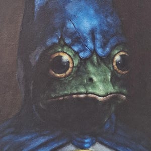 May include: A painting of a frog wearing a blue Batman cowl and cape. The frog's face is green with large, round eyes. A yellow emblem with a frog silhouette is on the chest.
