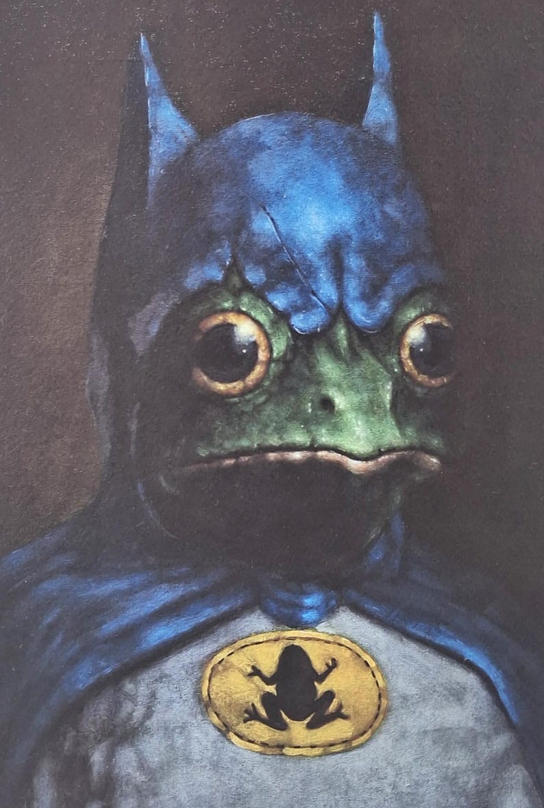 May include: A whimsical illustration of a frog dressed as Batman. The frog has a green face, large yellow eyes, and a blue cowl. A yellow emblem with a frog silhouette is on the chest. The artwork has a painterly style.