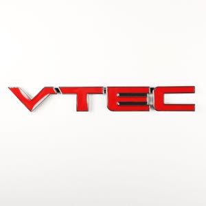 May include: Red VTEC emblem with a chrome finish. The letters are raised and have a black outline.