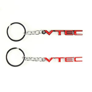 May include: Two keychains with the word "VTEC" in red lettering. Each keychain has a silver chain and a black key ring. The keychains are on a white background.