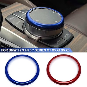 May include: Blue and red trim rings for a BMW car. The trim rings are round and have a smooth finish. The text "FOR BMW 1 2 3 4 5 6 7 SERIES GT X3 X4 X5 X6" is visible below the trim rings.
