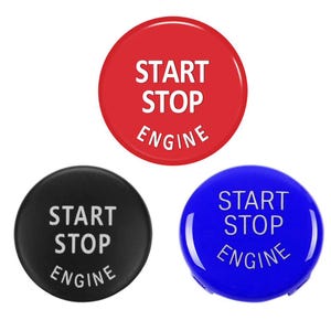 May include: Three round car start stop engine buttons. One is red, one is black, and one is blue. Each button has the words "START STOP ENGINE" printed on it in white.