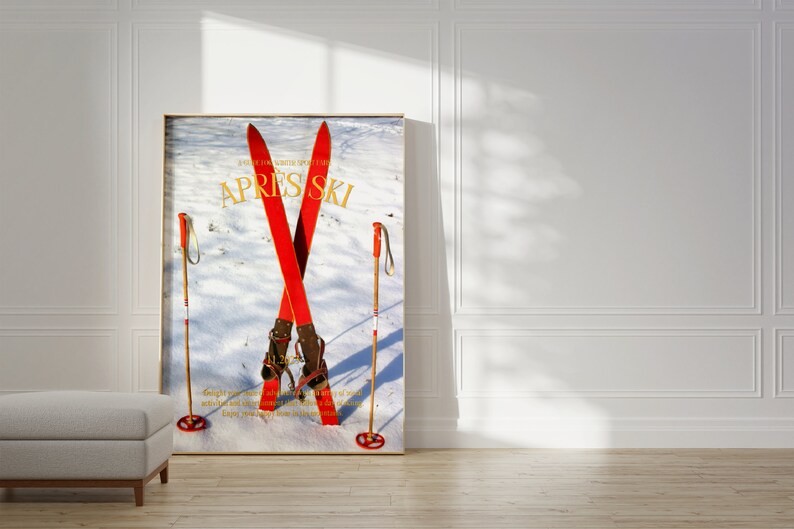 K&ouml;nnte beinhalten: Ein Vintage-Skiposter mit einem Paar roter Ski, die &uuml;bereinander gekreuzt sind, mit braunen Skischuhen und zwei Holzskist&ouml;cken. Das Poster hat einen wei&szlig;en Hintergrund mit einer verschneiten Landschaft und den Text "APRES SKI" in goldenen Buchstaben.
