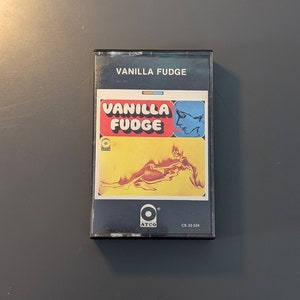 May include: A black cassette tape with a yellow, orange and red design. The text "Vanilla Fudge" is printed on the front of the tape in white letters. The tape is labelled "CS 33 224" and has the ATCO logo.