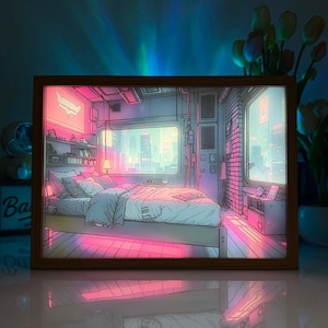 May include: A rectangular light box featuring an anime-style illustration of a bedroom with a bed, shelves, and a large window overlooking a city skyline. The scene is illuminated with vibrant pink and blue neon lighting, creating a glowing effect.