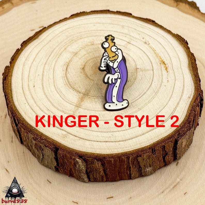 Puede incluir: Un pin de dibujos animados con un personaje con una t&uacute;nica morada con ribetes blancos, sosteniendo un cetro dorado. El pin est&aacute; etiquetado "Kinger - Style 2" en texto rojo. El pin est&aacute; sobre una rodaja de madera.