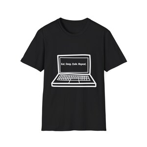May include: Black t-shirt featuring a white outline of a laptop. The laptop screen shows the words "Eat. Sleep. Code. Repeat." The design is a simple line drawing. The t-shirt is made of a soft material.