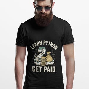 May include: A black V-neck t-shirt featuring a graphic of a snake, a stack of gold coins, and a money bag. The text reads "LEARN PYTHON" and "GET PAID" with programming code snippets in the background, including "def", "print", and brackets.
