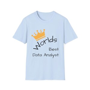 Può includere: T-shirt azzurra con la scritta "Worlds Best Data Analyst" in nero e una grafica a corona dorata. La t-shirt è a girocollo ed è realizzata in un materiale morbido.