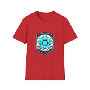May include: Red t-shirt with a circular emblem featuring a circuit board design in blue and teal. The emblem includes the text "PROUD NERD CLUB" in white. The shirt is a short-sleeved crew neck.