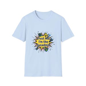 Pode incluir: Camiseta azul clara com a frase "Trust Me, I'm the Sysadmin". O gráfico apresenta um design de explosão amarelo com ícones de computador azuis e pretos.