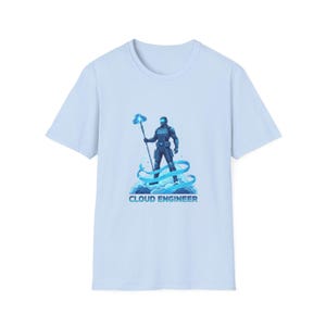 May include: Pale blue t-shirt with a graphic of a futuristic figure holding a staff, standing on clouds. The text "CLOUD ENGINEER" is below the graphic. The design is in shades of blue and white.