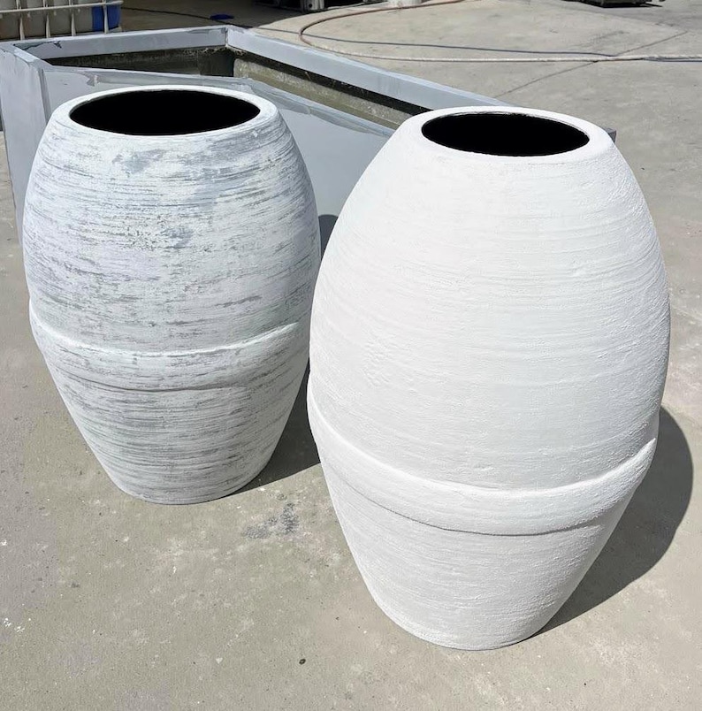 Pode incluir: Dois vasos de cer&acirc;mica branca com acabamento texturizado. O vaso &agrave; esquerda tem um lavado cinza claro, enquanto o vaso &agrave; direita &eacute; branco s&oacute;lido.