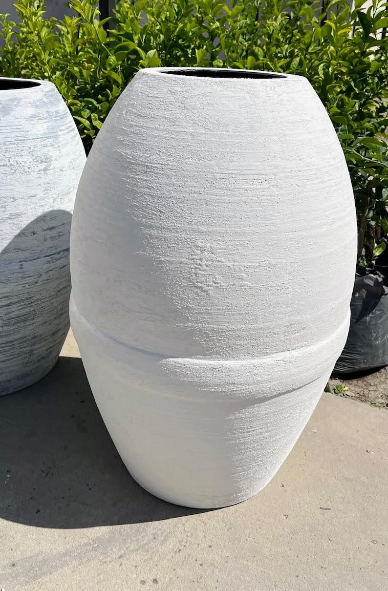 Pode incluir: Dois vasos de cer&acirc;mica branca com acabamento texturizado. O vaso maior &eacute; mais alto e mais largo que o menor.