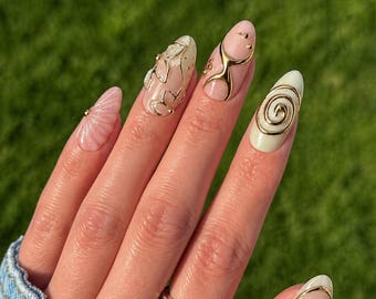 Uñas postizas estilo grunge rosa dorado: uñas postizas hechas a mano con forma de almendra, con diseño abstracto de remolino dorado en tonos pastel y forma de espiral dorada en 3D.