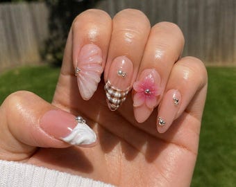 Uñas postizas 3D con diseño floral y de conchas marinas / Uñas postizas rosa nude con punta francesa y perlas / Uñas de novia de lujo estilo playero / Uñas de verano con forma de almendra / Uñas postizas para vacaciones