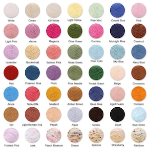 May include: A collection of yarn balls in various colors, including white, pink, blue, green, and yellow. Each ball is labeled with its color name, such as "White," "Pink," and "Blue Snow." Ideal for knitting and crochet projects.