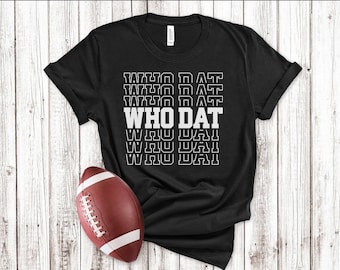 May include: Black t-shirt with the text "WHO DAT" repeated in a stacked, retro design. The shirt is laid out on a white wood background with a brown football to the left.