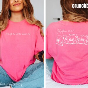 May include: Pink t-shirt with the text "He left the 99 to rescue me" on the front and the text "Matthew 18:11-13" and a line drawing of sheep on the back.