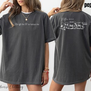 May include: An oversized t-shirt in a dark grey colour with the text "He left the 99 to rescue me" on the front and a graphic of sheep with the text "Matthew 18:11-13" on the back.