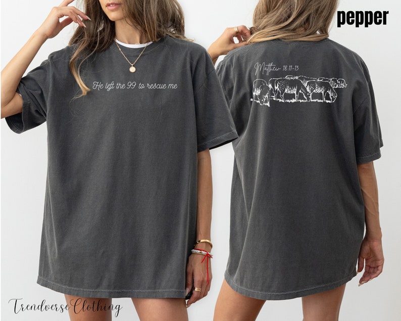 May include: An oversized t-shirt in a dark grey colour with the text "He left the 99 to rescue me" on the front and a graphic of sheep with the text "Matthew 18:11-13" on the back.
