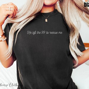 May include: A black t-shirt with the text "He left the 99 to rescue me" in white lettering.