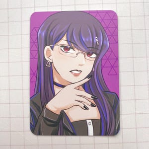 Puede incluir: Ilustraci&oacute;n de una mujer con cabello morado, gafas y esmalte de u&ntilde;as negro. Lleva un collar&iacute;n negro y una chaqueta negra sobre una blusa blanca. El fondo es un patr&oacute;n geom&eacute;trico p&uacute;rpura.