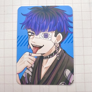 Puede incluir: Tarjeta rectangular con un personaje de estilo anime con cabello azul y un collar negro. El personaje tiene una venda sobre un ojo y una lengua afuera. El fondo es azul con rayas diagonales.