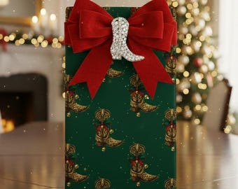 May include: A wrapped gift box with a green background and a pattern of gold cowboy boots. The box is adorned with a large red velvet bow and a silver rhinestone cowboy boot embellishment. The scene suggests a festive holiday setting.