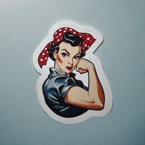 Può includere: Un'illustrazione in stile vintage di una donna con una fascia a pois rossi e bianchi, che flette il bicipite, indossando un'uniforme blu e oro.