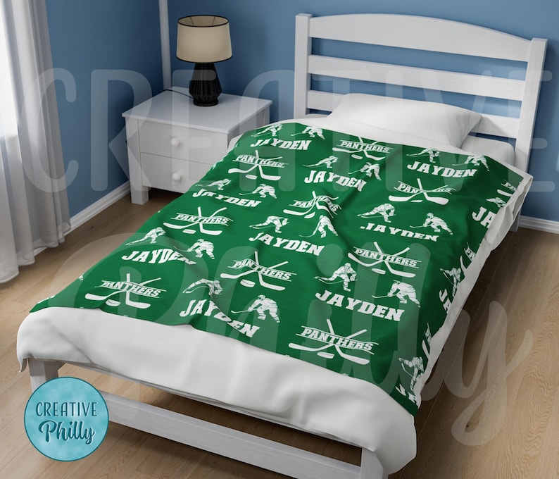 May include: Green and white fleece blanket with a hockey player and stick design. The blanket features the name "Jayden" and the words "Panthers" repeated throughout.