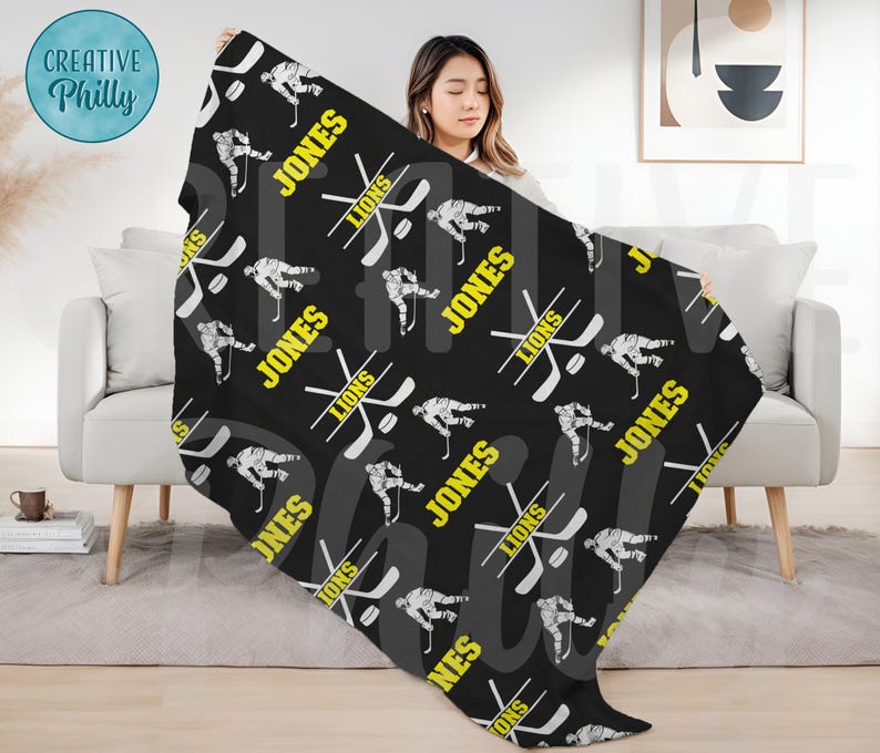 May include: Black and white hockey player pattern fleece throw blanket with the name "Jones" and the word "Lions" repeated throughout the design.