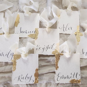 Segnaposto tradizionali calligrafici moderni strappati a mano, scritti a mano con nastro di seta e foglia d'oro