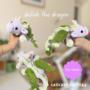 May include: Three crochet dragon plushies in light purple with dark green wings and spines, and cream-colored horns. The text reads delilah the dragon, no-sew, and CROCHET PATTERN. These soft toys feature black safety eyes and textured yarn.