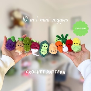 Puede incluir: Una colección de diez pequeñas verduras de ganchillo, que incluye una berenjena morada, una patata marrón, un pepinillo verde, un rábano rojo, una vaina de guisantes, una patata beige, una zanahoria naranja, una cebolla blanca, un chile rojo y un maíz verde claro, todos con caras bordadas.