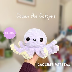Può includere: Un peluche a forma di polpo lavorato all'uncinetto color viola chiaro con grandi occhi di sicurezza neri, una piccola bocca ricamata e guance rosa. La parte inferiore dei tentacoli è giallo pallido. Il testo sull'immagine recita: Ocean the Octopus, no-sew, CROCHET PATTERN.