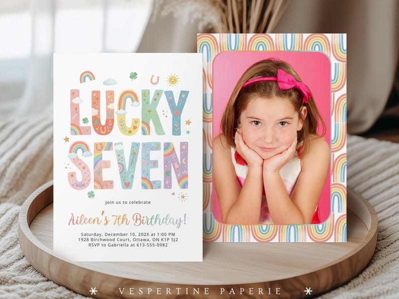 May include: Two invitations on a wooden tray. One invitation features the text "LUCKY SEVEN" in colorful letters with rainbow and star illustrations. The second invitation has a photo of a girl with a pink bow, framed by a rainbow border.