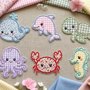 Puede incluir: Seis parches de tela bordados con criaturas marinas: una ballena con flores azules, un delfín de cuadros rosas, una tortuga de cuadros verdes, un pulpo de cuadros morados, un cangrejo con flores rojas y un caballito de mar de cuadros amarillos.