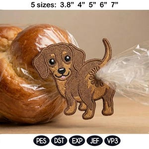 Könnte beinhalten: Gestickter brauner Dackel-Aufnäher mit einem lächelnden Gesicht. Der Aufnäher ist in fünf Größen erhältlich: 9,65 cm, 10,16 cm, 12,7 cm, 15,24 cm und 17,78 cm. Der Aufnäher enthält die folgenden Dateitypen: PES, DST, EXP, JEF und VP3.