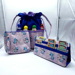 May include: A set of three fabric organizers featuring a Stitch character print. Includes a drawstring bag with bottles, a zippered pouch, and a card holder. The drawstring bag is blue with a purple lining.