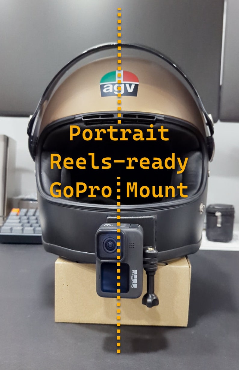 May include: A black motorcycle helmet with a gold visor and a GoPro camera mount. The GoPro is mounted on a cardboard box. Text on the helmet reads "Portrait Reels-ready GoPro Mount".