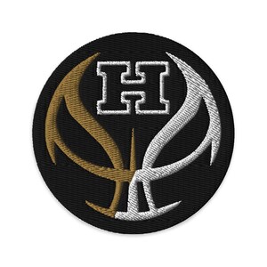 Puede incluir: Una pelota de baloncesto negra y blanca con un contorno dorado y la letra "H" en el centro. La pelota de baloncesto está bordada en un parche circular negro.