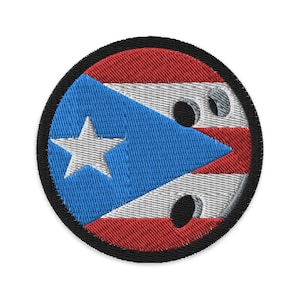 Op de afbeelding: Geborduurde ronde patch met de vlag van Puerto Rico. Het ontwerp bevat een blauwe driehoek met een witte ster, afwisselend rode en witte strepen en een zwarte rand.