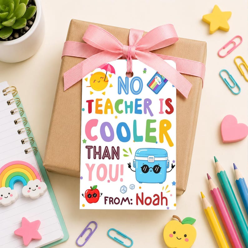 May include: A gift tag with the text "No Teacher Is Cooler Than You!" in colorful letters. The tag features illustrations of a sun, a lunchbox, and an apple. The tag is attached to a brown gift box with a pink ribbon.