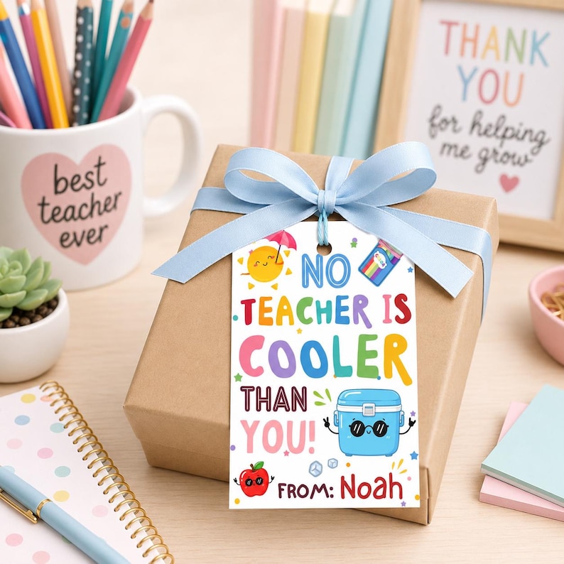 May include: A gift box wrapped in brown paper and tied with a light blue ribbon. A tag with the text "NO TEACHER IS COOLER THAN YOU! FROM: Noah" is attached. A mug with "best teacher ever" is in the background.